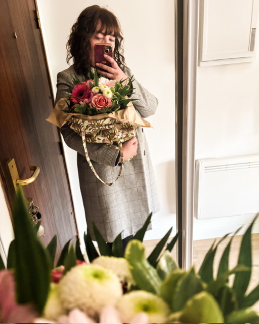 Selfie dans un miroir, bouquet de fleurs dans les bras