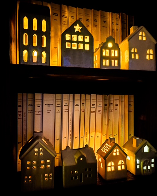 Collection de petites maisons en céramique dans une bibliothèque